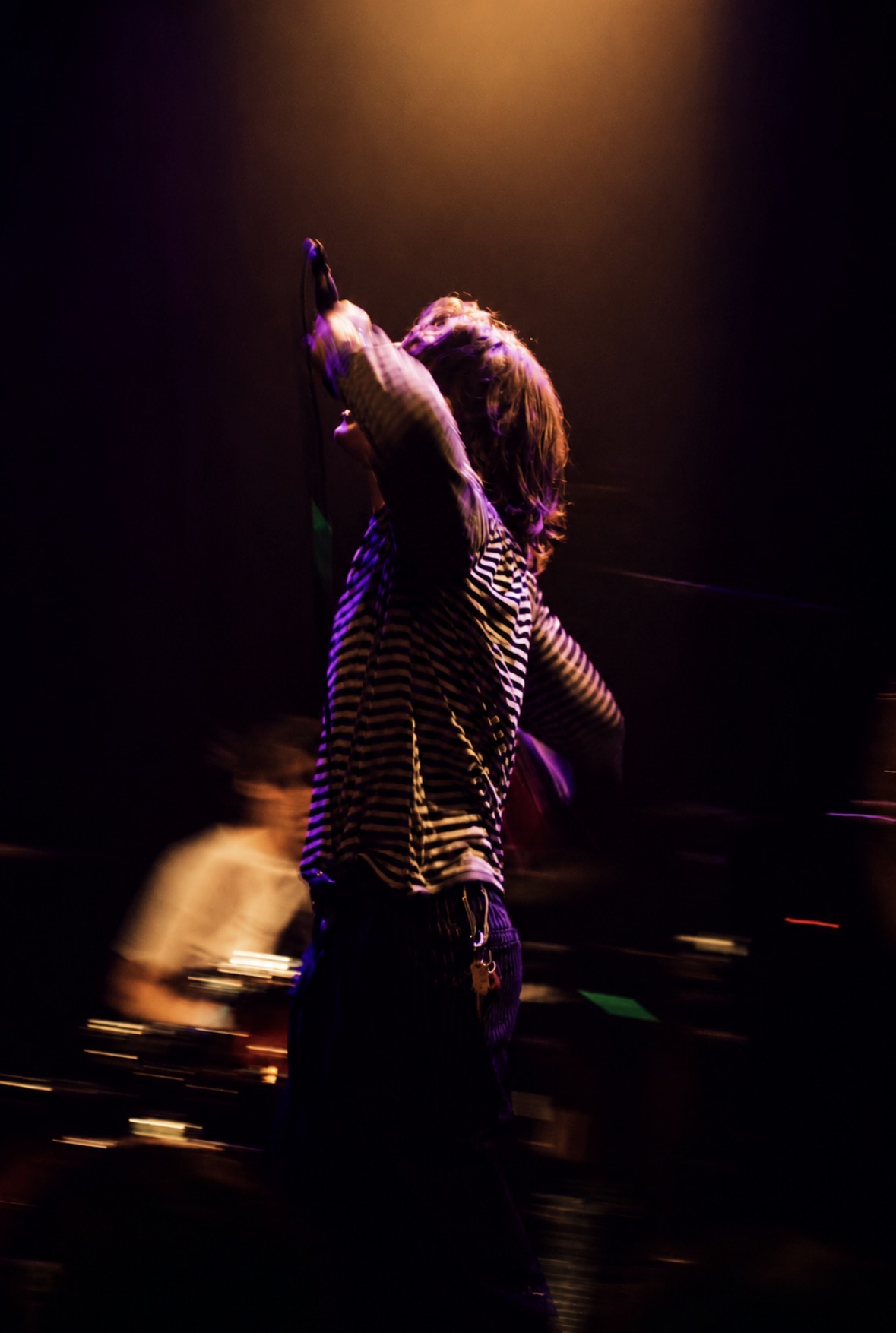 Singer reaching toward the microphone with motion blur