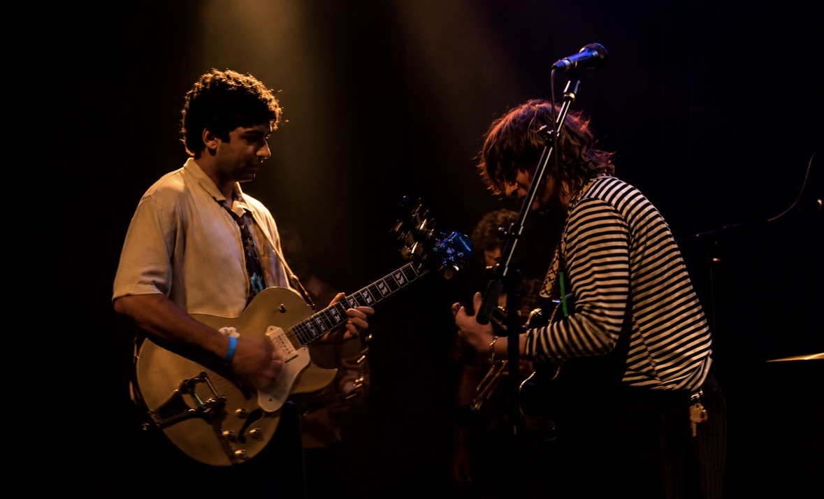 Two guitarists performing face to face