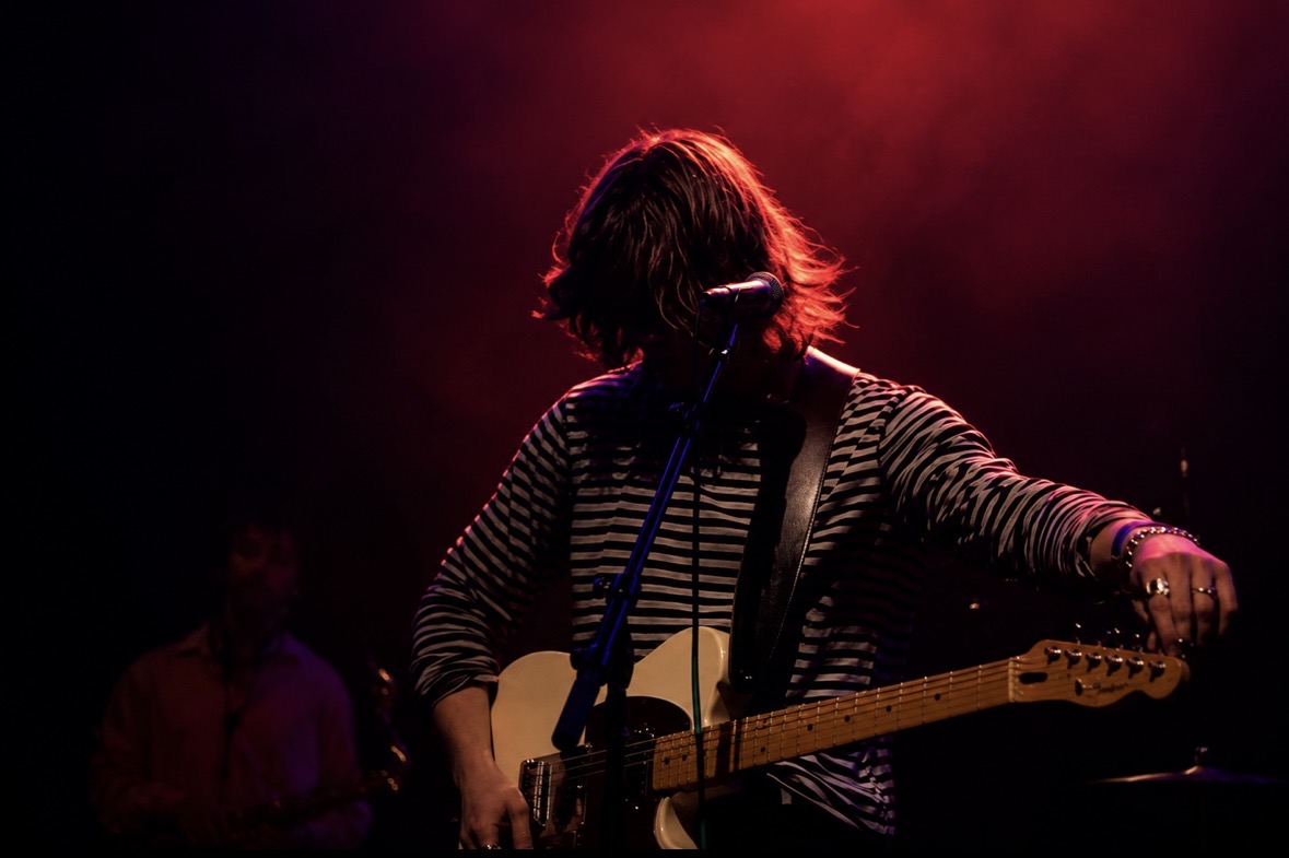 Guitarist silhouetted by red stage light