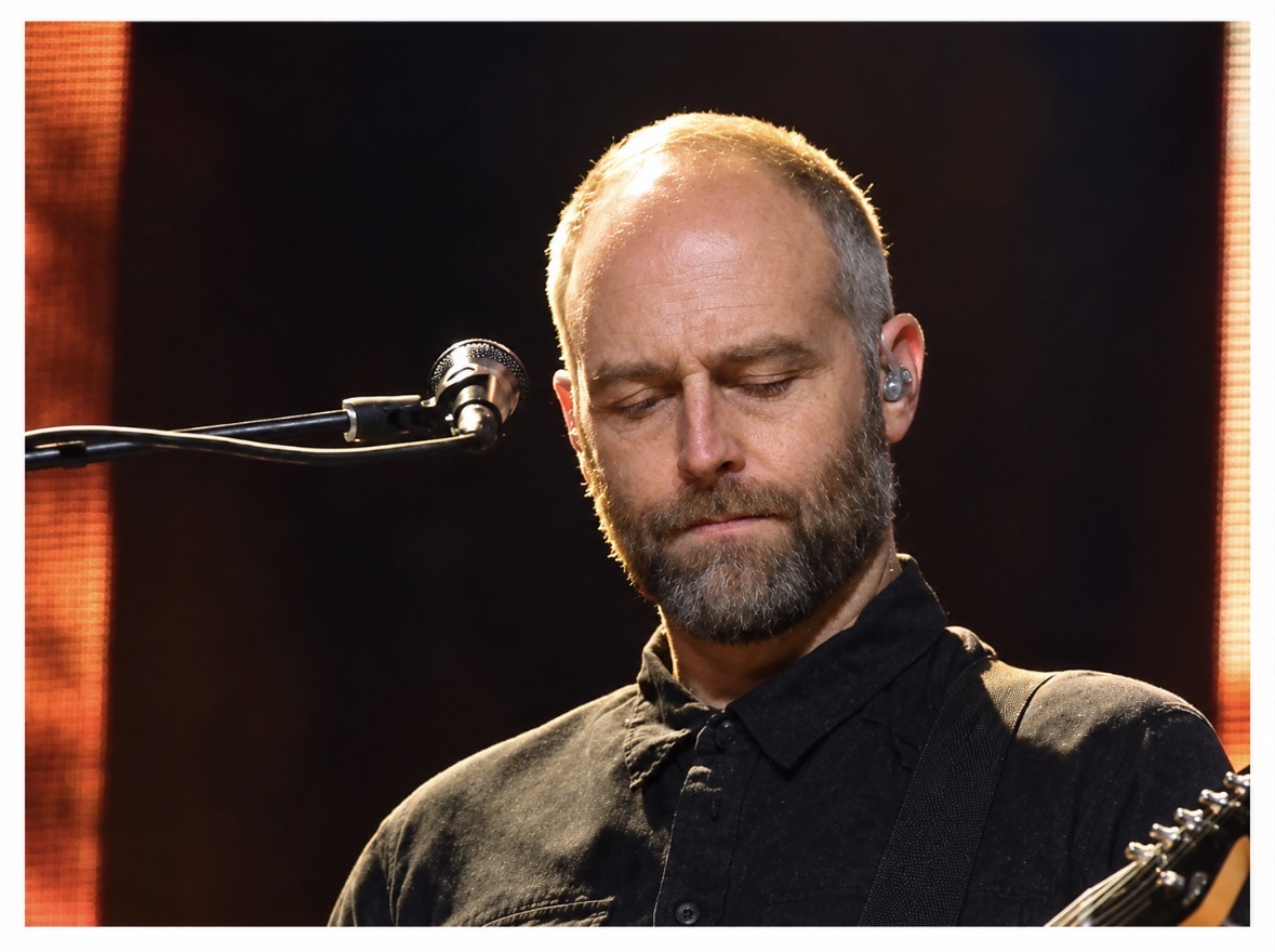 Close-up of a musician with eyes closed and warm rim lighting